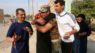 Un combatiente kurdo abraza a su hermana tras arrebatar al EI una localidad al norte de Mosul.