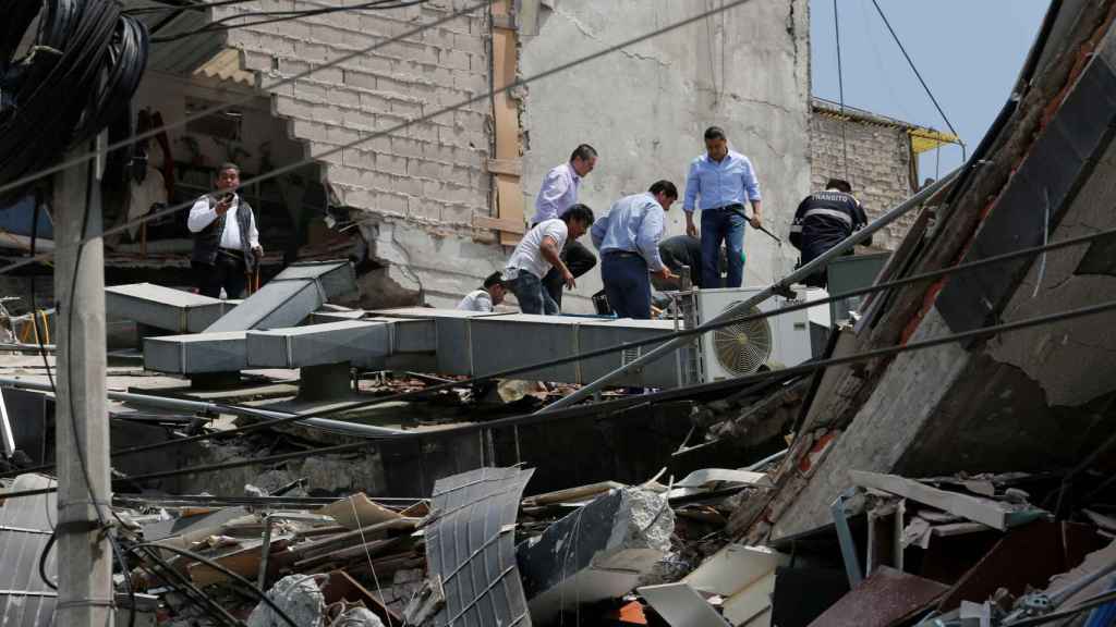 Equipos de rescate buscan posibles víctimas en un edificio colapsado.