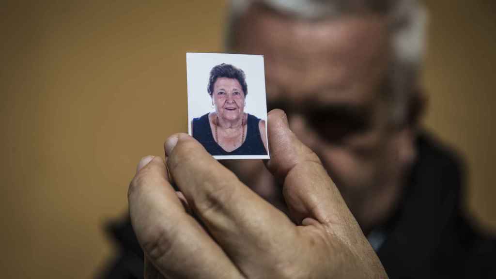 José Luis Nuñez, para quien la fallecida, María de La Luz, de 80 años, era su 'segunda madre' sosteniendo su foto, que lleva consigo en la cartera.